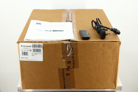 Box of a used PS Audio Stellar Strata Mk1 Integrated Amplifier in black finish showing mains cable, manual, and remote