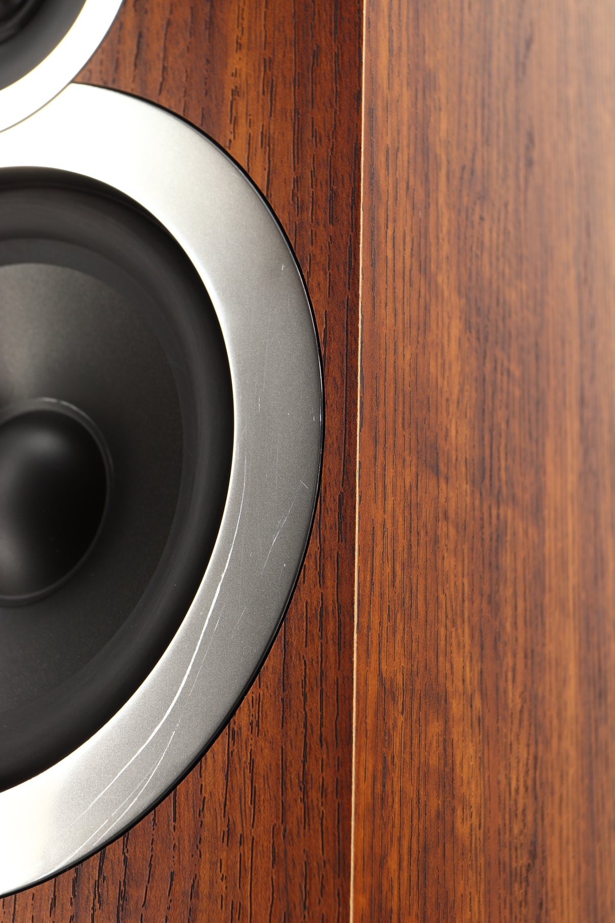 Close up of a used Q Acoustics 3050i Floorstanding Speakers in a walnut finish showing scratching on bass driver surround