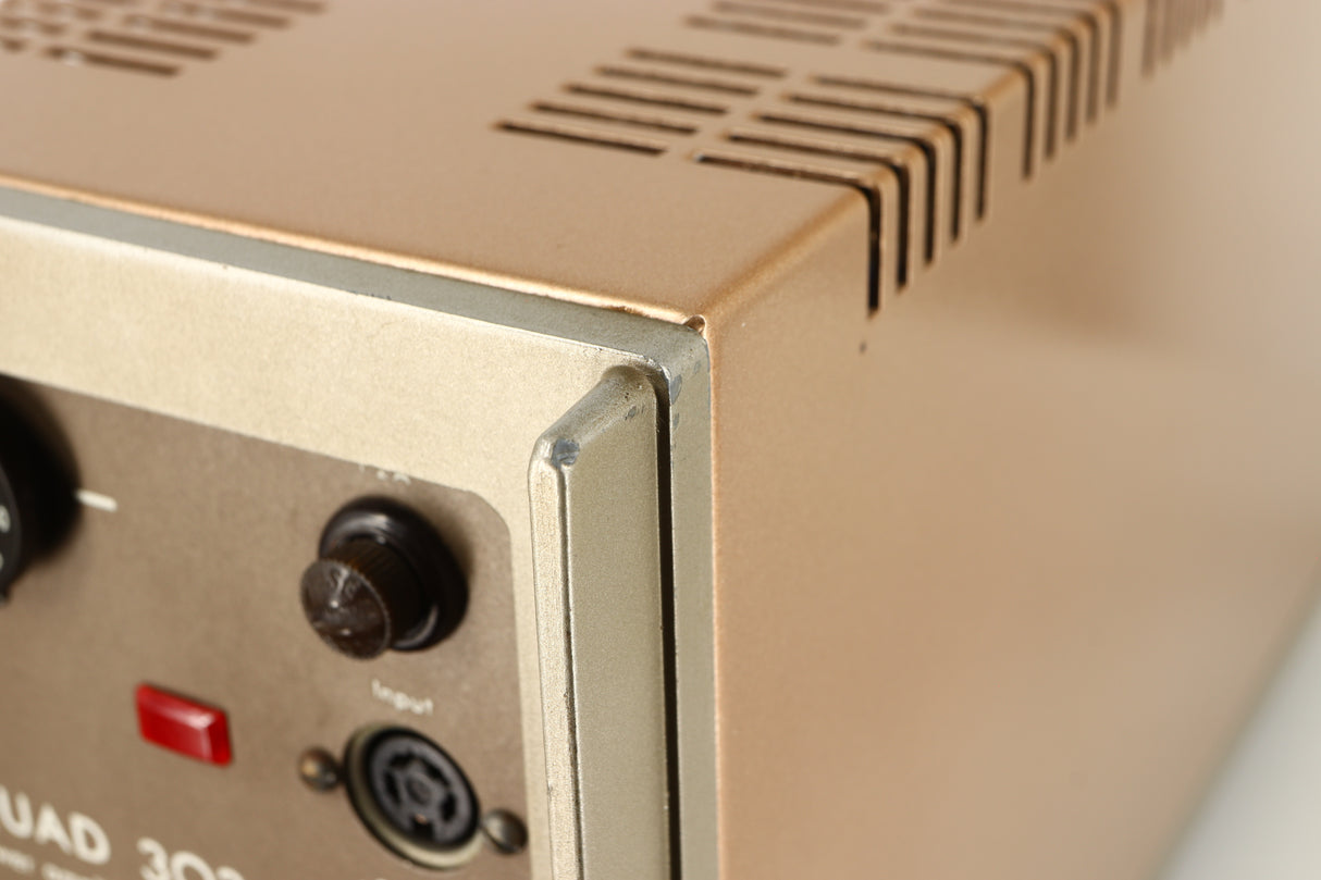 Close up of a used Quad 303 Power Amplifier showing some damage on rear left corner