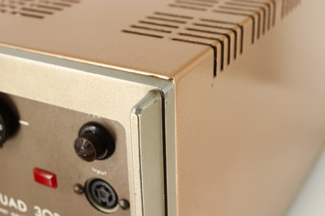 Close up of a used Quad 303 Power Amplifier showing some damage on rear left corner