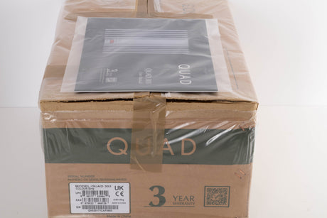 Box for a used Quad 303 Power Amplifier in a Silver finish showing Manual