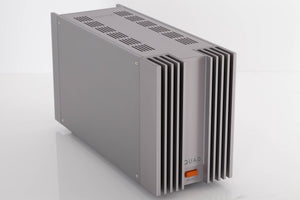 Front left corner of a used Quad 303 Power Amplifier in a Silver finish