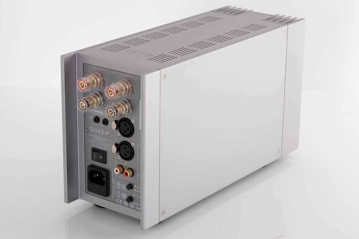Rear left corner of a used Quad 303 Power Amplifier in a Silver finish
