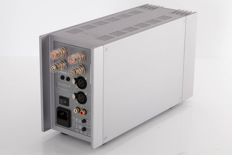 Rear left corner of a used Quad 303 Power Amplifier in a Silver finish