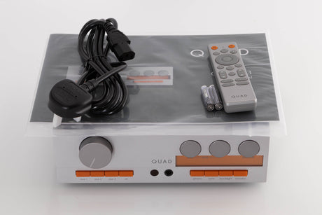 Top of a used Quad 33 Pre Amplifier in a Silver finish showing Manual, Remote, Batteries and Mains Cable