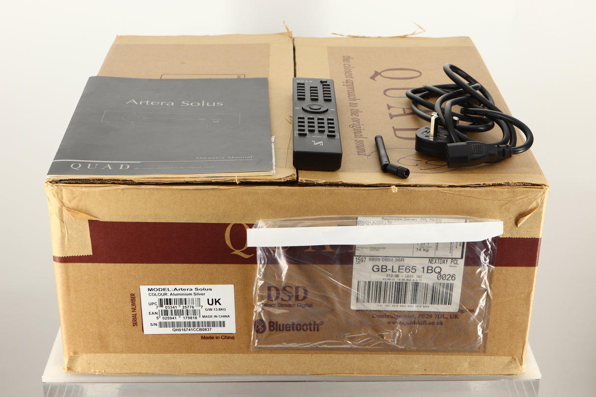 Box of a used Quad Artera Solus Integrated System in Silver finish showing mains cable, manual, remote, and antenna 
