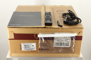 Box of a used Quad Artera Solus Integrated System in Silver finish showing mains cable, manual, remote, and antenna 