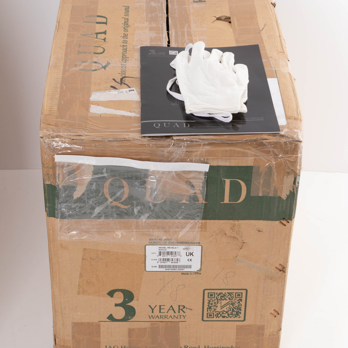 Box for a used Quad Revela 1 Standmount Speaker in a Walnut finish showing Manual and Gloves