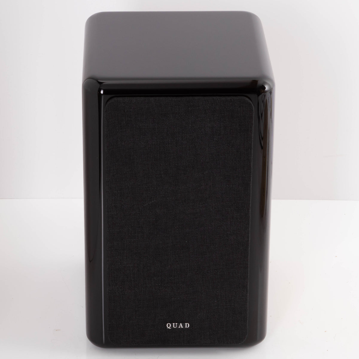 Front view of a used Quad Revela 1 Standmount Speaker in a Walnut finish showing Grille