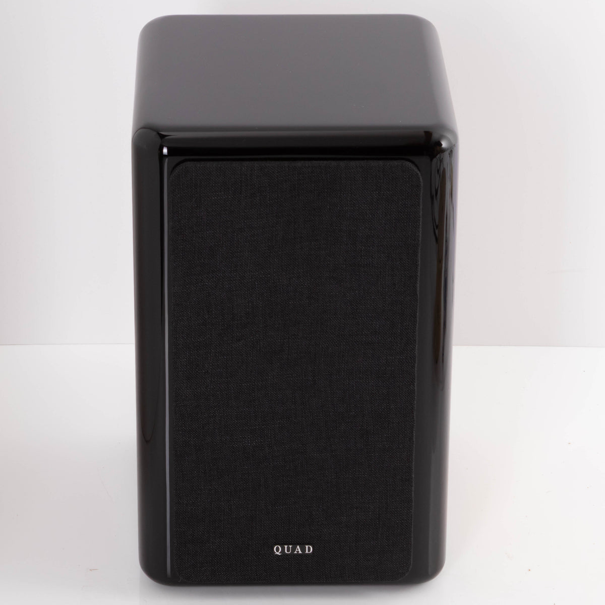 Front view of a used Quad Revela 1 Standmount Speaker in a Walnut finish showing Grille