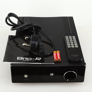 Top view of a used Rega Brio-R Integrated Amplifier in a black finish showing manual, mains cable, remote and 2x batteries