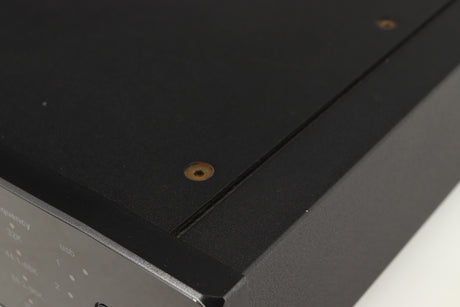 Close up of a used Rega DAC Digital Analogue Converter in a black finish showing small nick on right side edge