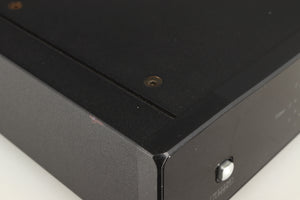 Close up of a used Rega DAC Digital Analogue Converter in a black finish showing small nick on left side edge