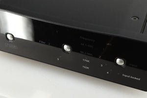 Close up of a used Rega DAC-R Digital Analogue Converter in a black finish showing scratching on the screen