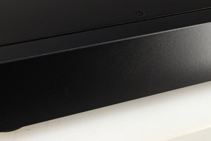 Close up of a used Rega Elex-R Integrated Amplifier in a black finish showing marks on right side