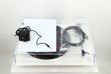 Top view of a used Rega Planar 1 Plus Turntable in a white finish showing a manual, power supply and an interconnect cable
