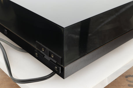 Rear left corner of a used Rega Planar 3 Turntable 24V Upgraded in a black finish