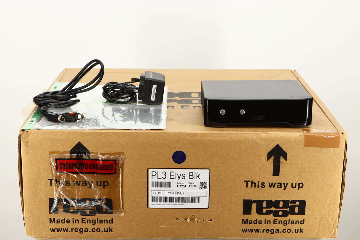 Box for a used Rega Planar 3 Turntable / Ortofon 2M Bronze Cartridge / NEO Power Supply in a black finish showing Manual, PSU, XLR Cable and Cartridge Alignment Protractor