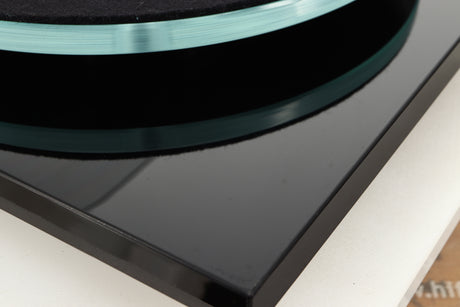 Close up of a used Rega Planar 3 Turntable / Ortofon 2M Bronze Cartridge / NEO Power Supply in a black finish showing some scratching and spots on unit