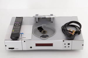 Top of a used Rega Planet CD Player in a Silver finish showing Mains Cable, Remote, Batteries and Manual