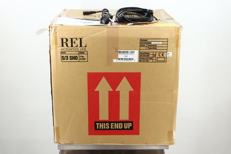 Box of a used REL S/3 SHO Subwoofer in Piano Black finish showing mains cable, manual, and hi-level cable