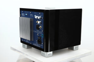 Rear left corner of a used REL T-7X Subwoofer in a piano black finish