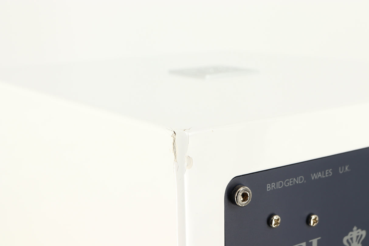 Close up of a used REL T-Zero MKIII Subwoofer in a piano white finish showing damage on rear right corner