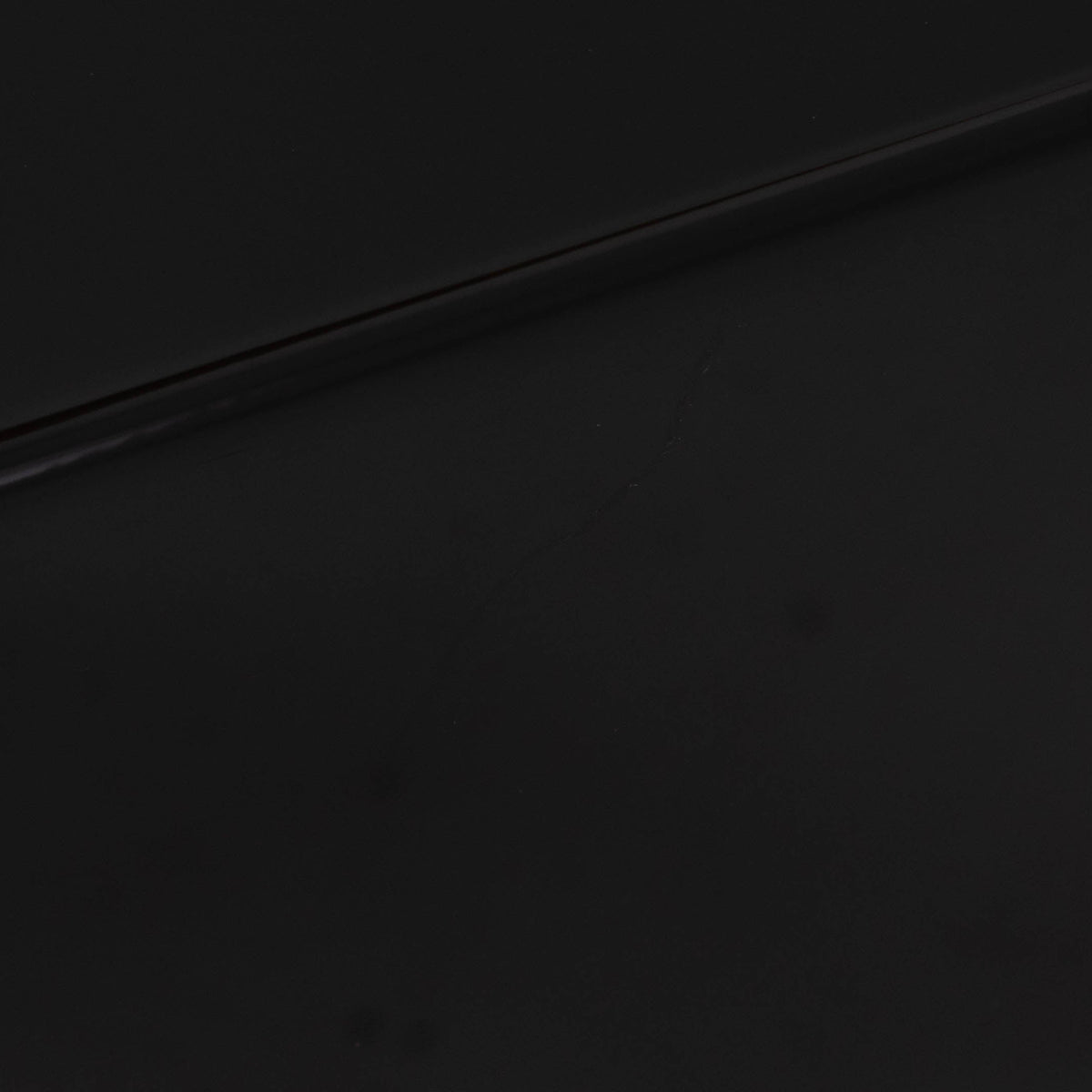 Close up of a used REL T-Zero Subwoofer in a Piano Black finish showing scratch on left side