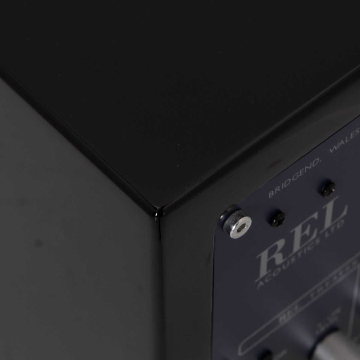 Rear right corner of a used REL T-Zero Subwoofer in a Piano Black finish