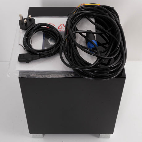 Top of a used REL T5i Subwoofer in a Piano Black finish showing Manual, Mains Cable and Hi-Level Cable