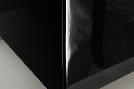 Close up of a REL T5i Subwoofer with a piano black finish showing feet like marks
