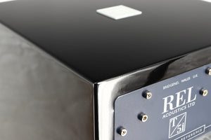 Close up of a used REL T5i Subwoofer in a piano black finish showing graze on rear edge