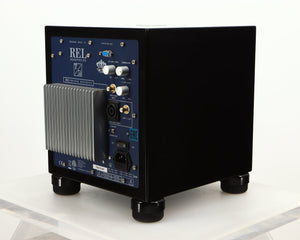 Rear left corner of a used REL T5i Subwoofer W/ Upgraded Feet in a piano black finish