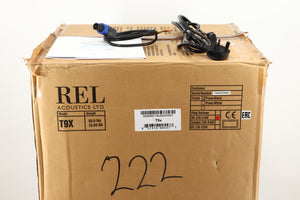Box of a used REL T9X Subwoofer in Piano Black finish showing mains cable, manual, and Hi-Level cable