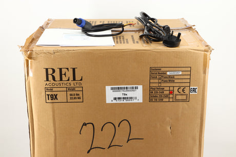 Box of a used REL T9X Subwoofer in Piano Black finish showing mains cable, manual, and Hi-Level cable