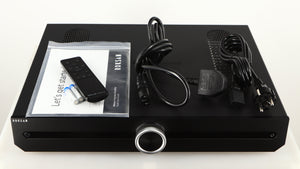 Top of a used Roksan Attessa Integrated Amplifier in a black finish showing Manual, Remote, 2x Batteries, Mains Cable and Schuko Cable