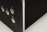 Close up view of a used Roksan BLAK CD Player in Charcoal finish showing some dents on the front right corner 