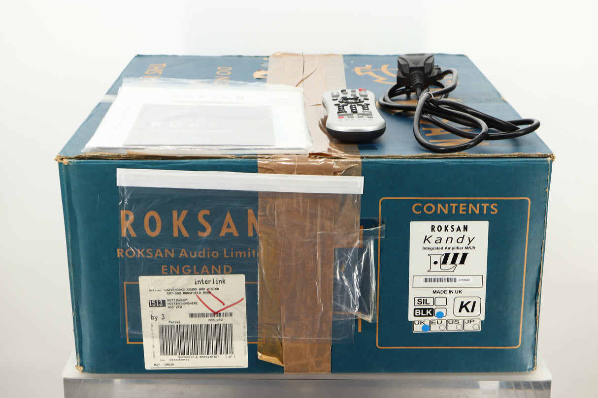 Box of a used Roksan Kandy KA-1 MkIII Integrated Amplifier in Black finish showing mains cable, manual, and remote