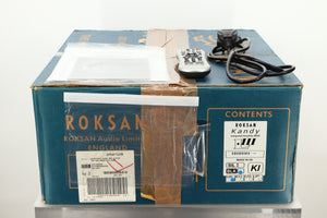 Box of a used Roksan Kandy KA-1 MkIII Integrated Amplifier in Black finish showing mains cable, manual, and remote