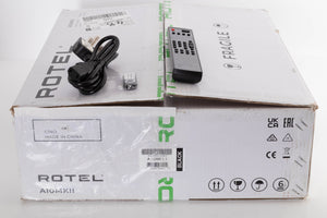 Box of a used Rotel A10 MKII Integrated Amplifier in Black finish with mains cable, remote, and USB stick