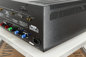 Rear left corner of a used Rotel RMB1075 Power Amplifier in a black finish 