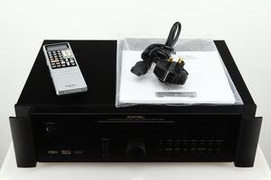 Top of a used Rotel RSP-1066 Pre Amplifier / Processor in a black finish showing Remote, Mains Cable and Manual 