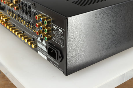 Rear left corner of a used Rotel RSP-1066 Pre Amplifier / Processor in a black finish