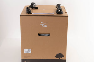Box of a used Ruark Audio RS-1 Subwoofer in Soft Grey with mains cable, manual, and sub cable