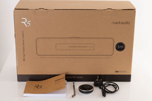 Box of a used Ruark R5 Music System in Soft Grey with mains cable, remote, manual, and antenna