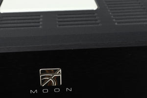 Close up view of a used Simaudio Moon 860A V2 Power Amplifier in black finish showing and small scratch on the front edge above the emblem