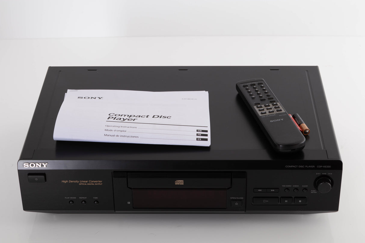 Top of a used Sony CDP-XE330 CD Player in a Black finish showing Manual, Remote and Batteries