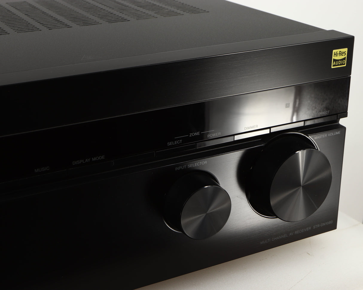 Close up of a used Sony STR-DN1080 AV Receiver in a black finish showing light scratch near volume knob