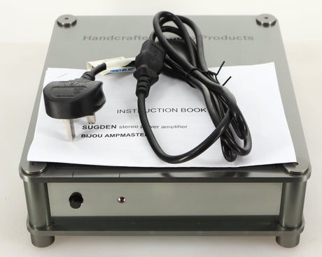 Top of a used Sugden Bijou Ampmaster Power Amplifier in a silver finish showing Manual and Mains Cable