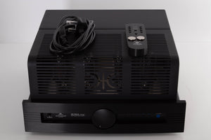 Top of a used Synthesis Roma 753AC Valve Integrated Amplifier in a Black finish showing Remote, Batteries and Mains Cable